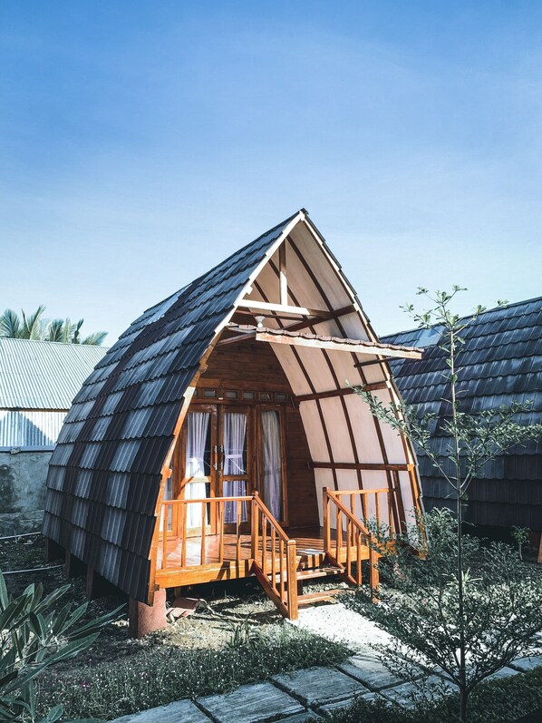 A small, wooden cabin with a pitched roof and a wooden porch.