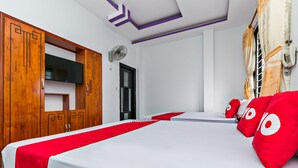 A hotel room with a bed, a TV, a wooden wardrobe, and a red and white bedspread. - Loan Anh 2 Hotel (Da Nang)