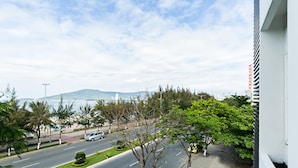 A street view with a road, trees, and a distant mountain range. - Loan Anh 2 Hotel (Da Nang)