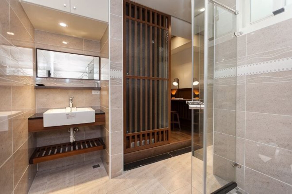 Une salle de bain moderne avec un lavabo, un miroir et un espace douche.