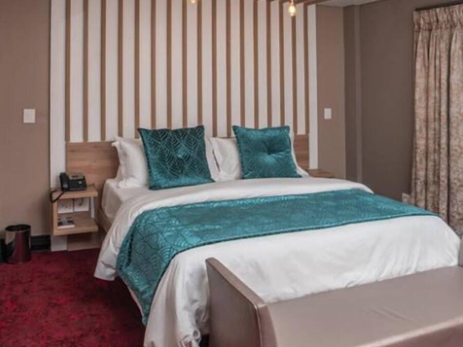 Un dormitorio moderno con una cama, mesitas de noche y una alfombra roja.