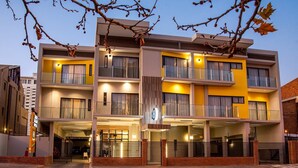 A multi-story hotel with balconies, a visible entrance, and a parking area. - Loch Logan Hotel (Bloemfontein)