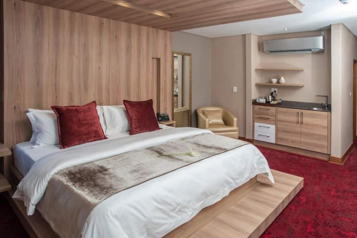 Ein modernes Hotelzimmer mit einem großen Bett, einem Schreibtisch und einer Küchenzeile.
