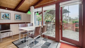 Ein Essbereich mit Tisch, Stühlen, einem Fernseher und Kunstwerken an der Wand.
