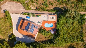 Vista aèria d'una propietat amb piscina, panells solars i una zona tancada per una tanca.