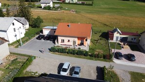 An aerial view of a residential area with houses, a parking lot, and a small garden. - Guest House Macic (Plitvicka Jezera)