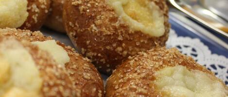 Une assiette de petits gâteaux ronds à la croûte dorée et à la garniture crémeuse bien visible.