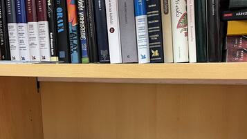 A bookshelf with a variety of books, some with visible titles and authors.