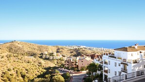 Un pueblo costero con edificios blancos, cielo azul despejado y vista al mar.