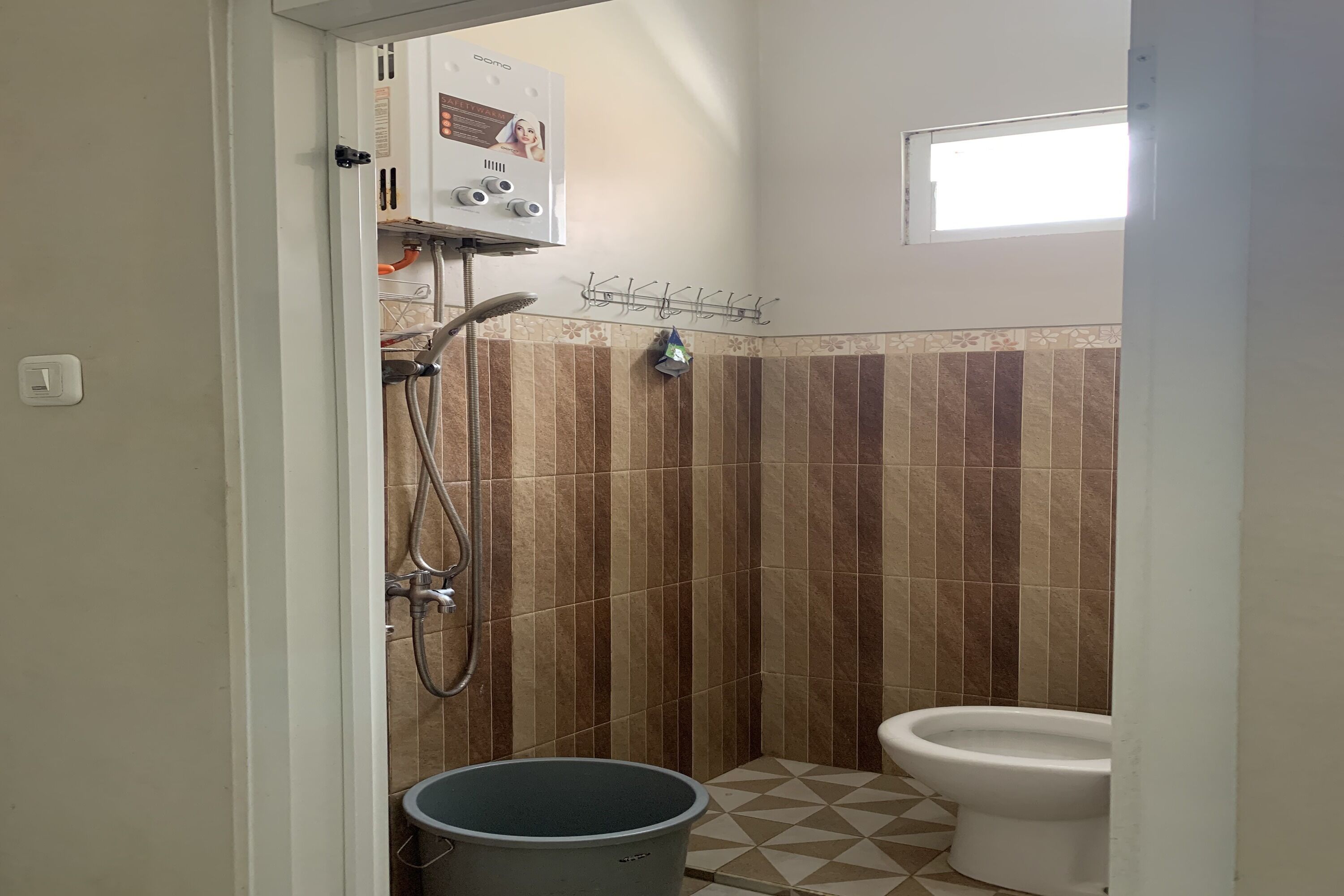 Une salle de bain équipée d’une douche, de toilettes et d’un chauffe-eau.