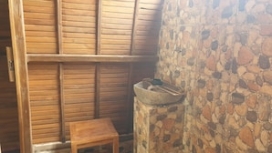 Un interior de madera con pared de piedra y un taburete de madera.