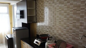 A modern kitchen with a black countertop, stainless steel appliances, and a tiled backsplash.