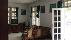 A living room with a sofa set, a television, speakers, and a cabinet. - Villa 3 Putri 27 (Batu)