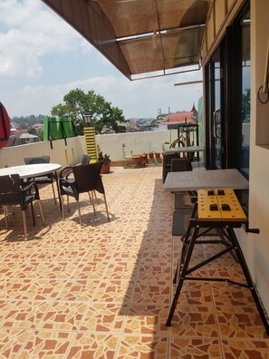 Une terrasse sur le toit, dotée d’un sol carrelé, de mobilier d’extérieur et de plantes en pot.