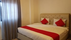 Une chambre d’hôtel avec un lit, des rideaux et une tête de lit.