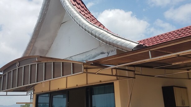 Un bâtiment doté d’un toit en pente, de grandes fenêtres et d’un distributeur d’eau.