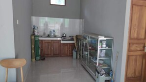 Una cocina funcional con armarios de madera, una encimera y un alacena con puerta de vidrio.