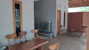 Un comedor con mesa y sillas de madera, un aparador de vidrio y una pared de ladrillo.