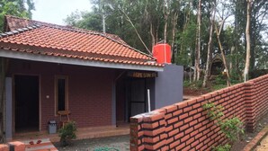 Una casa de dos pisos con techo de tejas rojas, fachada de ladrillo y un letrero que dice 'HOME STAY'.