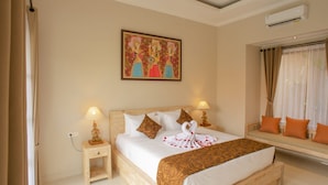 Une chambre d’hôtel avec un grand lit, deux tables de chevet avec des lampes, un climatiseur fixé au mur et une fenêtre avec des rideaux.