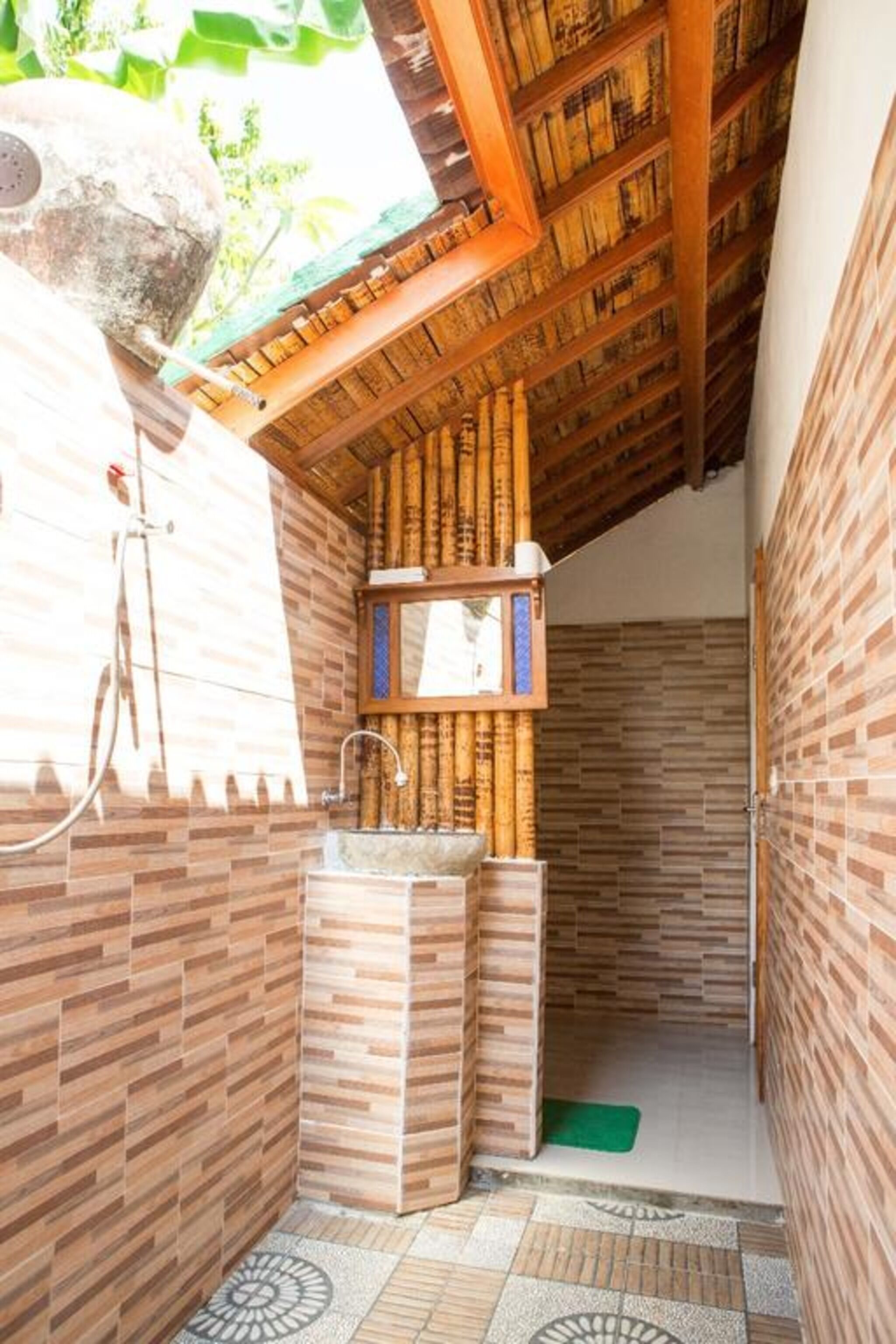 Un baño pequeño y cerrado con techo de madera y paredes de azulejos.