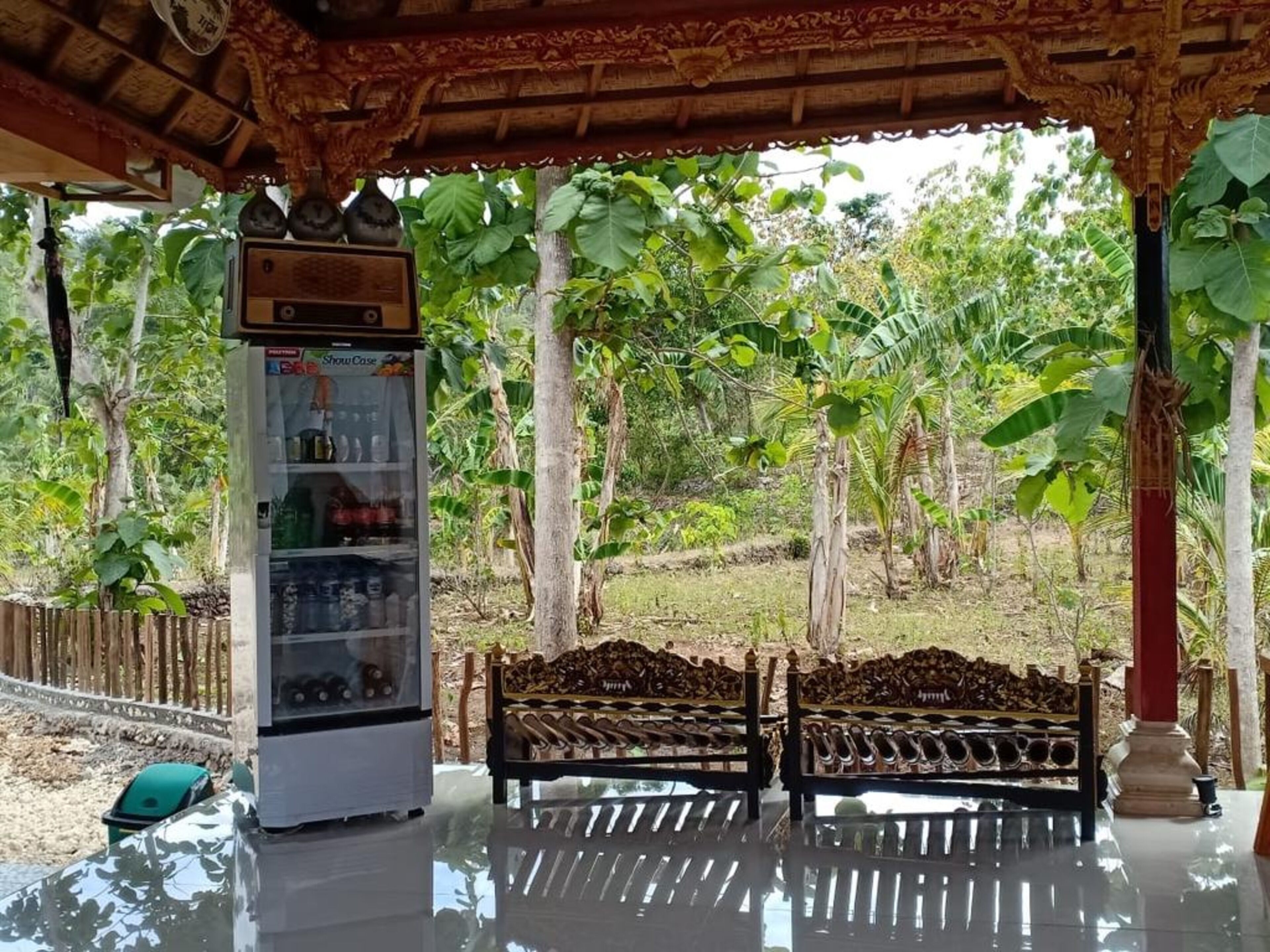 A covered outdoor seating area with a vending machine and a bench.