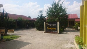 L’entrée d’un immeuble, avec une enseigne indiquant « Penginapan Sriwijaya ».