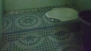 A small, tiled bathroom with a single toilet and a patterned floor.