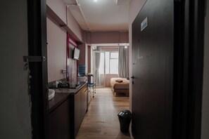 A narrow hallway leading to a bedroom with a bed and a window. - The Jarrdin by Bethania Pro by Zuzu (Bandung)