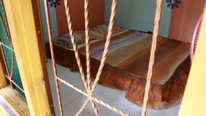 Una habitación con cama, una silla y una mesa.