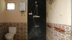 Un bagno con un WC, una doccia e uno scaldabagno.