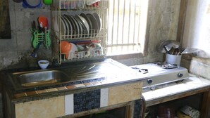 Una cucina con lavello, scolapiatti e fornello.