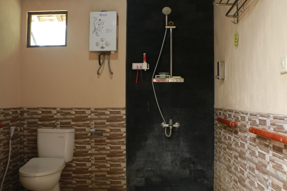 A bathroom with a toilet, a shower, and a water heater.
