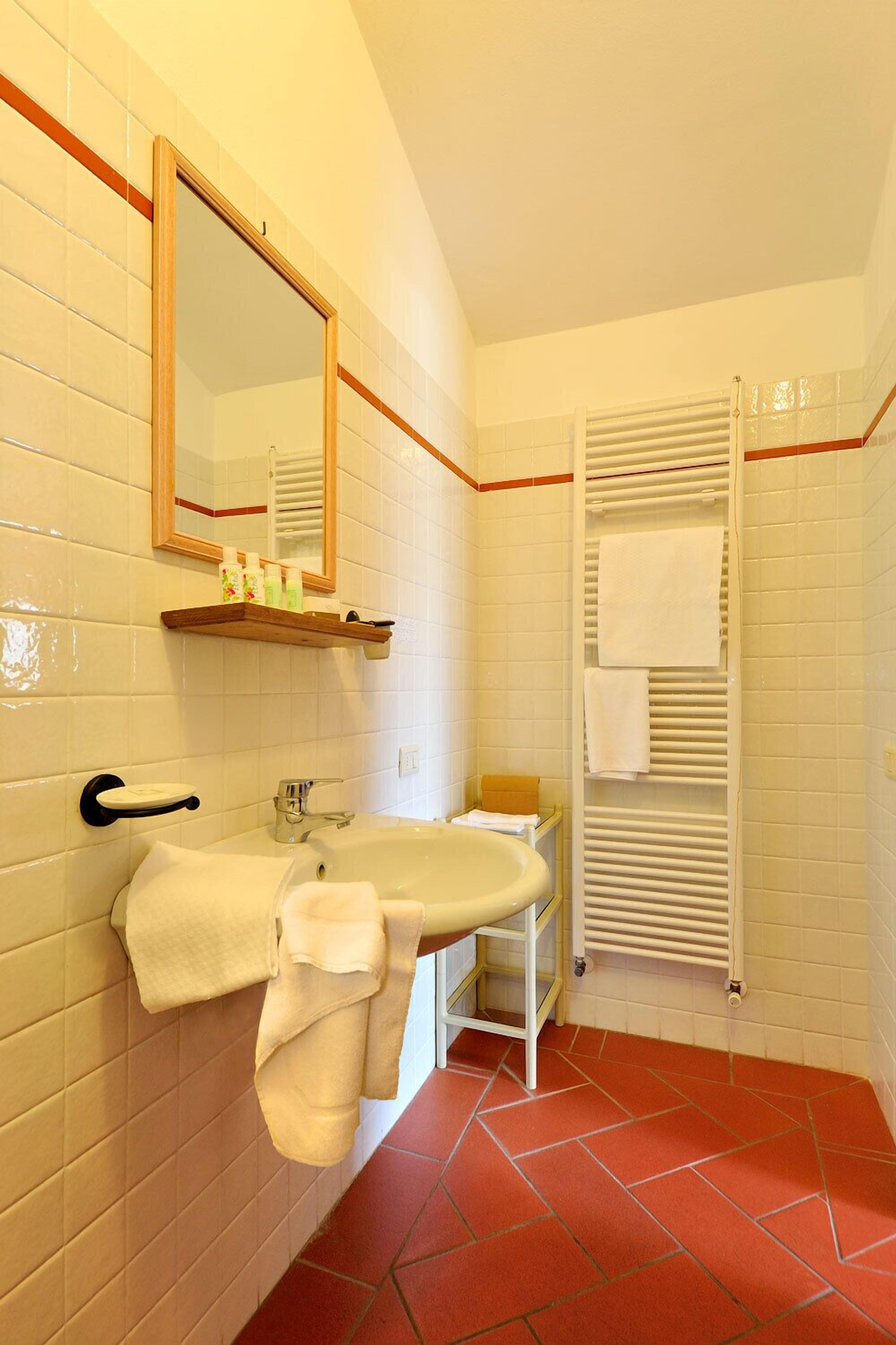 A bathroom with a white sink, mirror, and towel rack.