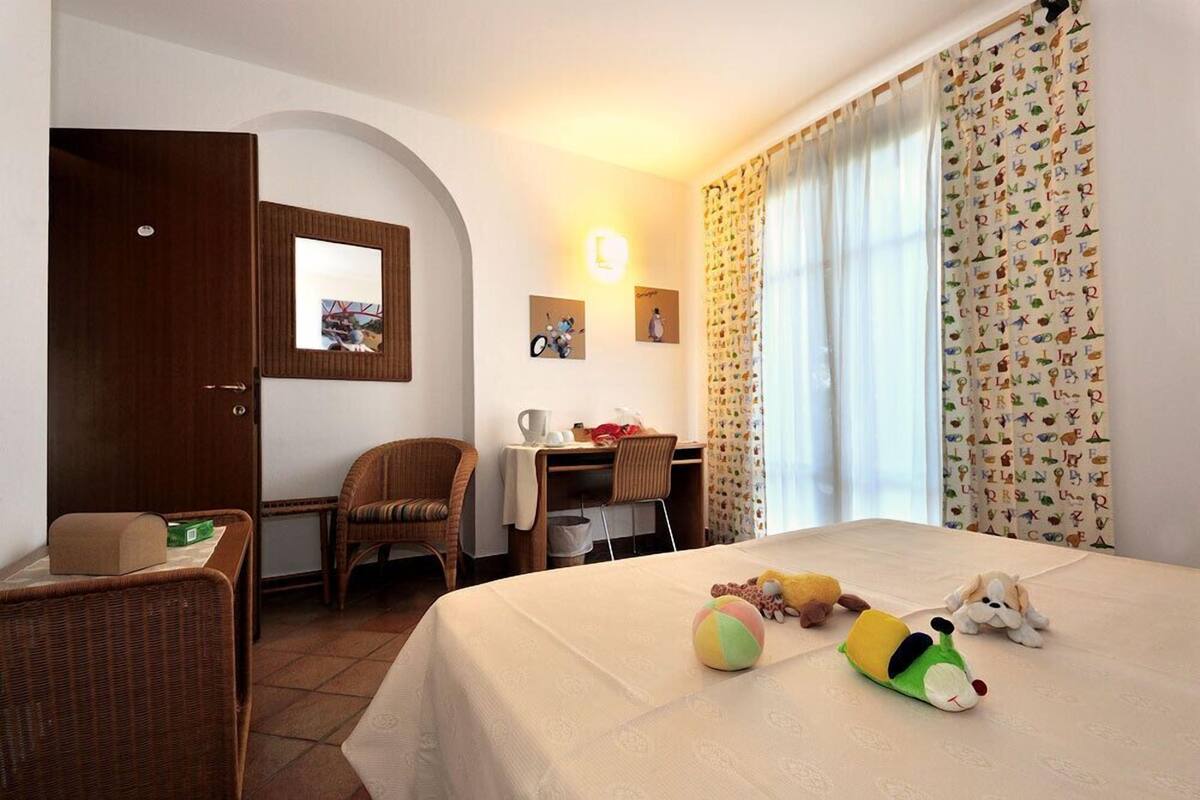 Ein Hotelzimmer mit Bett, Schreibtisch, Stuhl und kleinem Tisch.