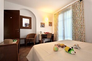 Une chambre d’hôtel avec un lit, un bureau, une chaise et une petite table.