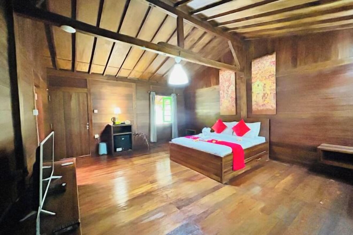 Une pièce en bois avec un lit, un bureau et une chaise.