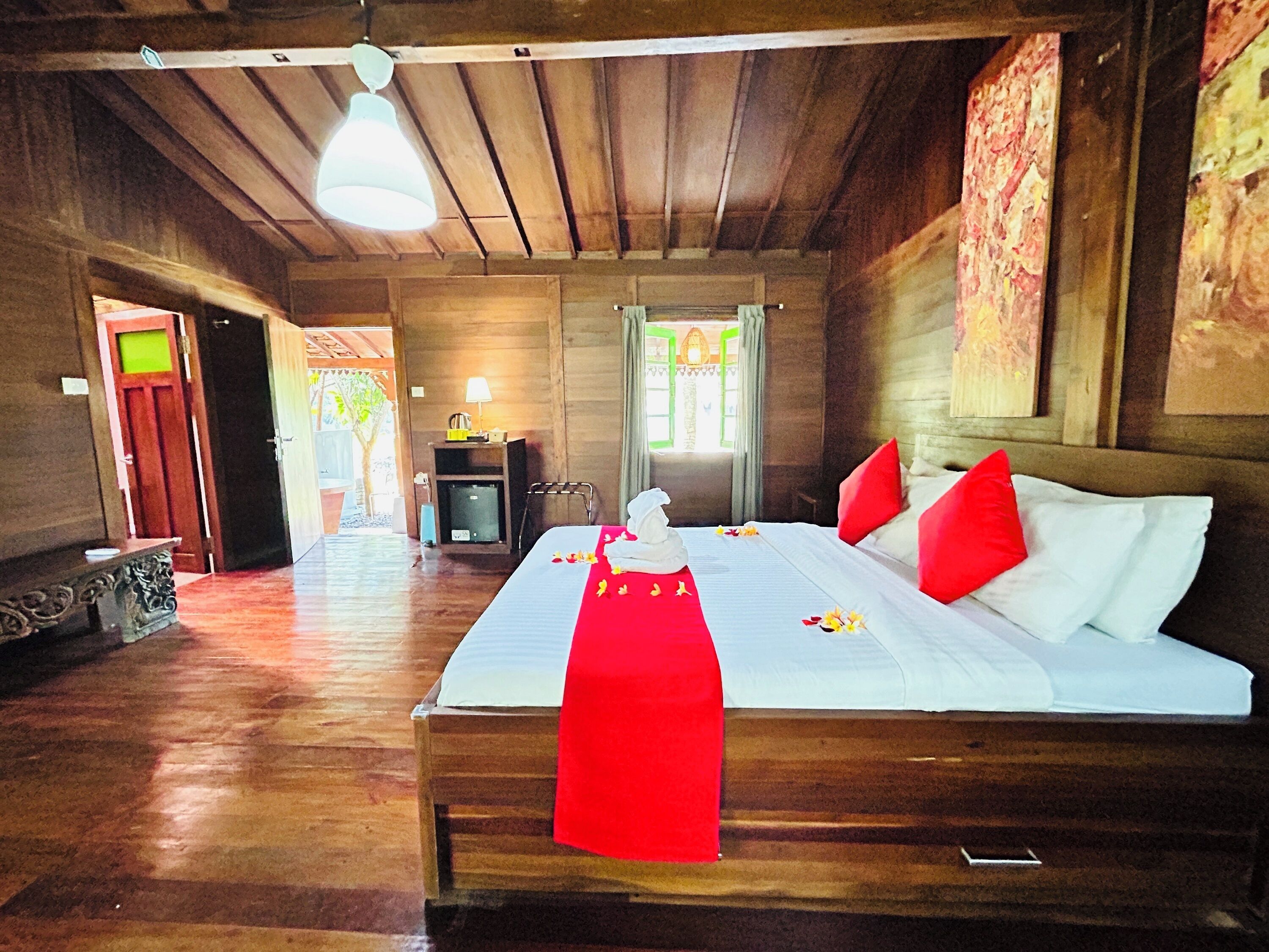 Ein Zimmer mit Holzboden, einem Bett, einem Schreibtisch und einem Stuhl.