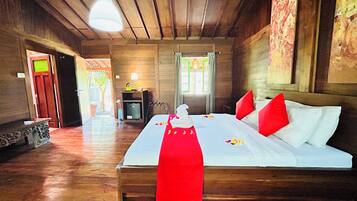 A wooden room with a bed, a desk, and a chair.