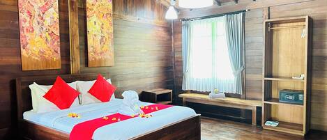 Ein Zimmer mit Holzboden, einem Bett, einer Bank und einem Schrank.