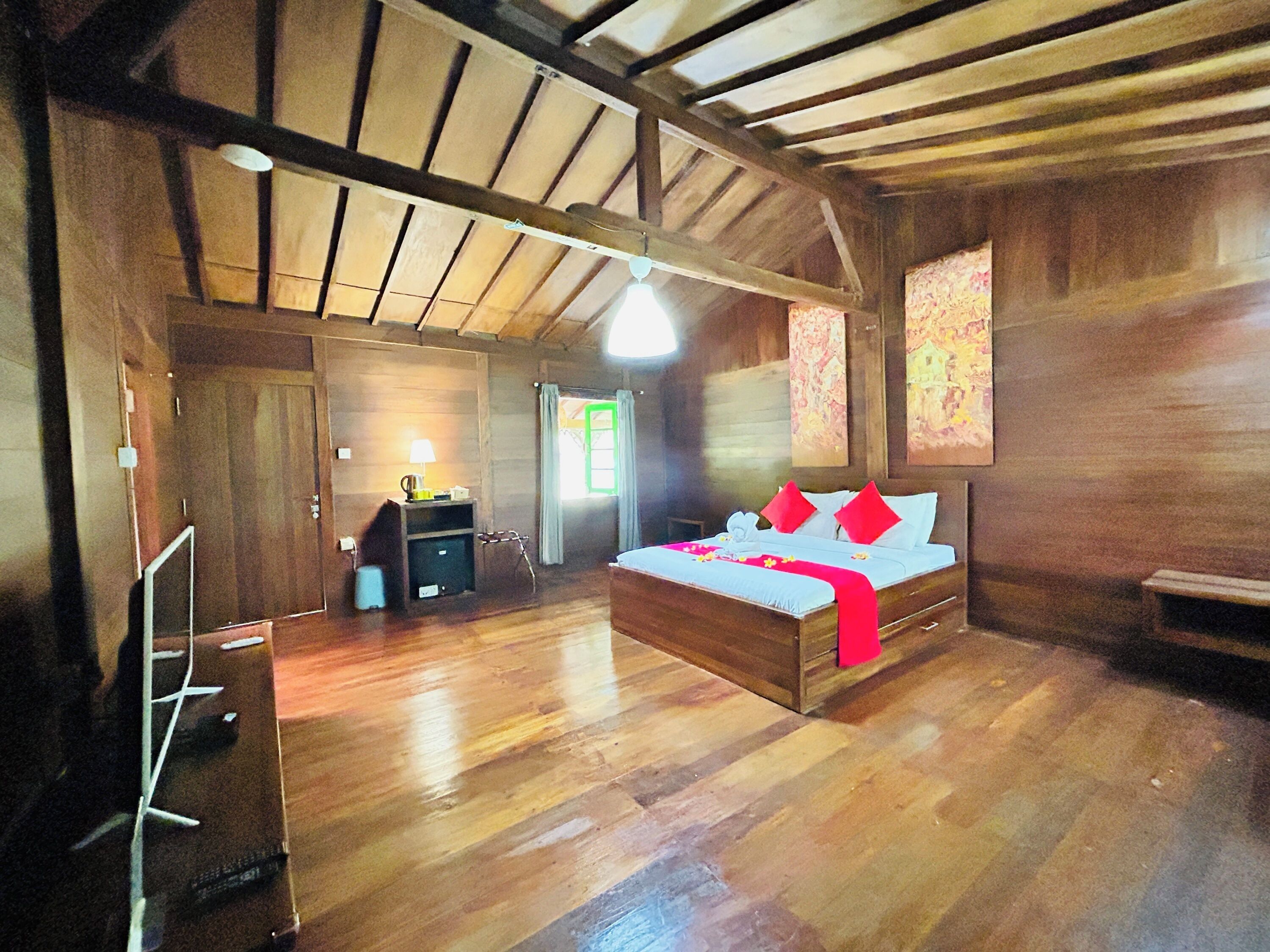 Une chambre avec un plancher en bois, comprenant un lit, un bureau et une chaise.