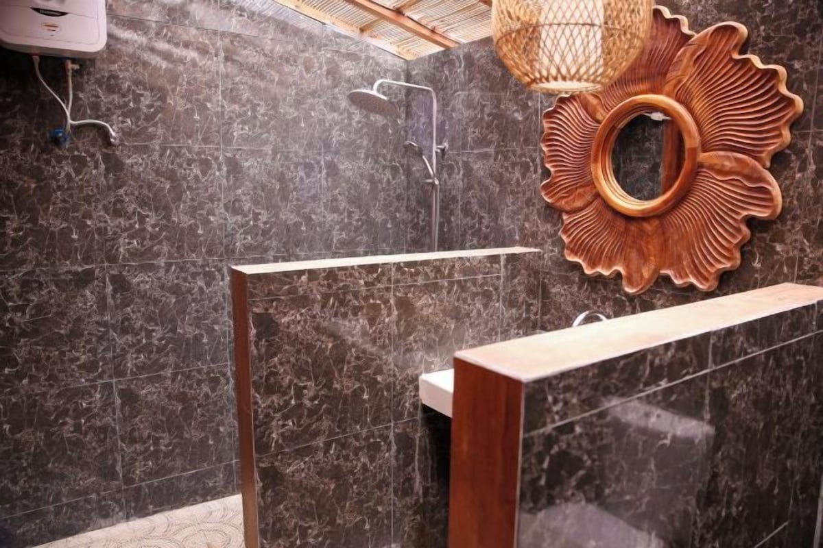 Un baño con ducha, tocador de madera y un adorno en la pared.