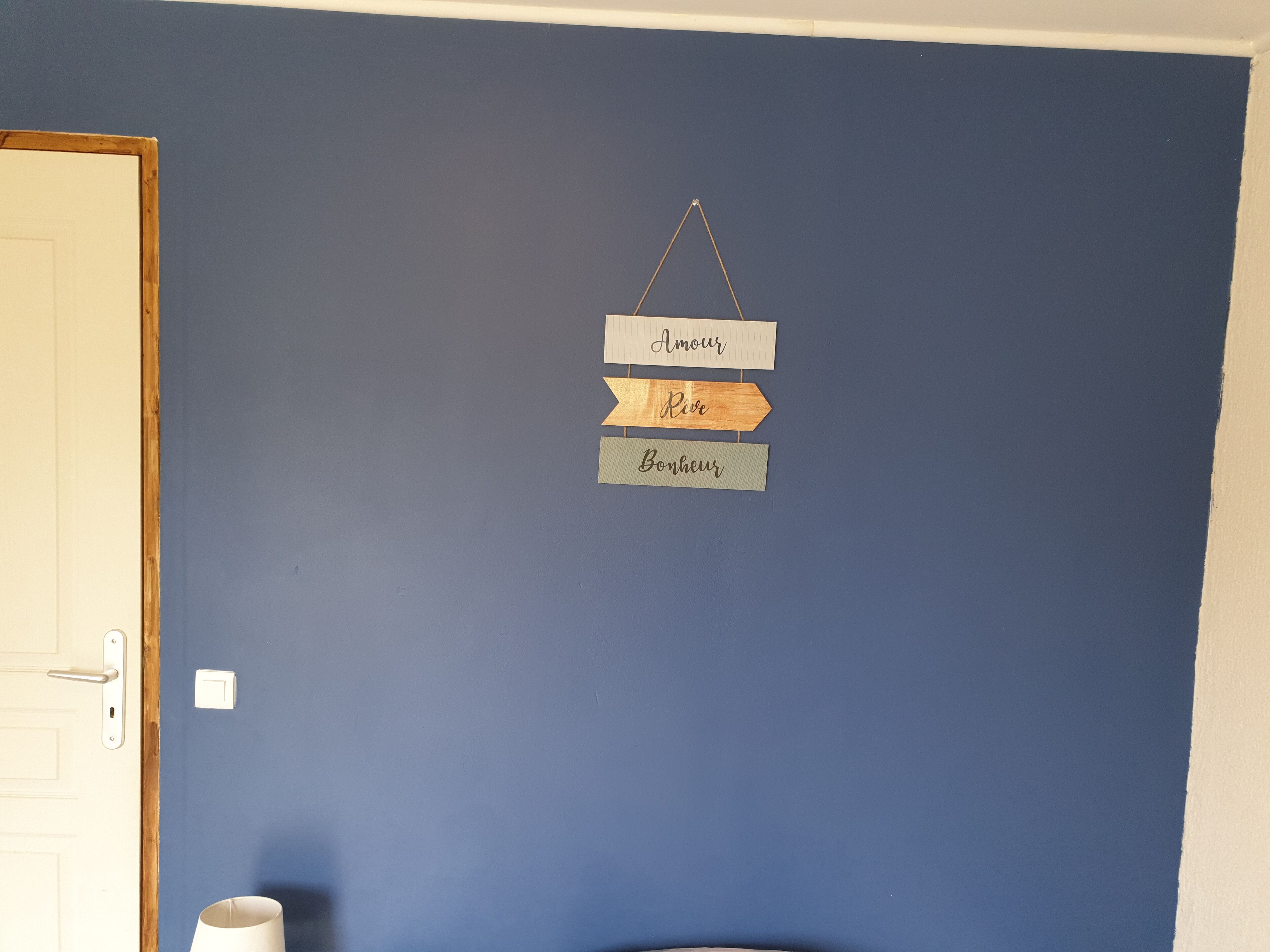 A wall with a sign hanging from the ceiling.