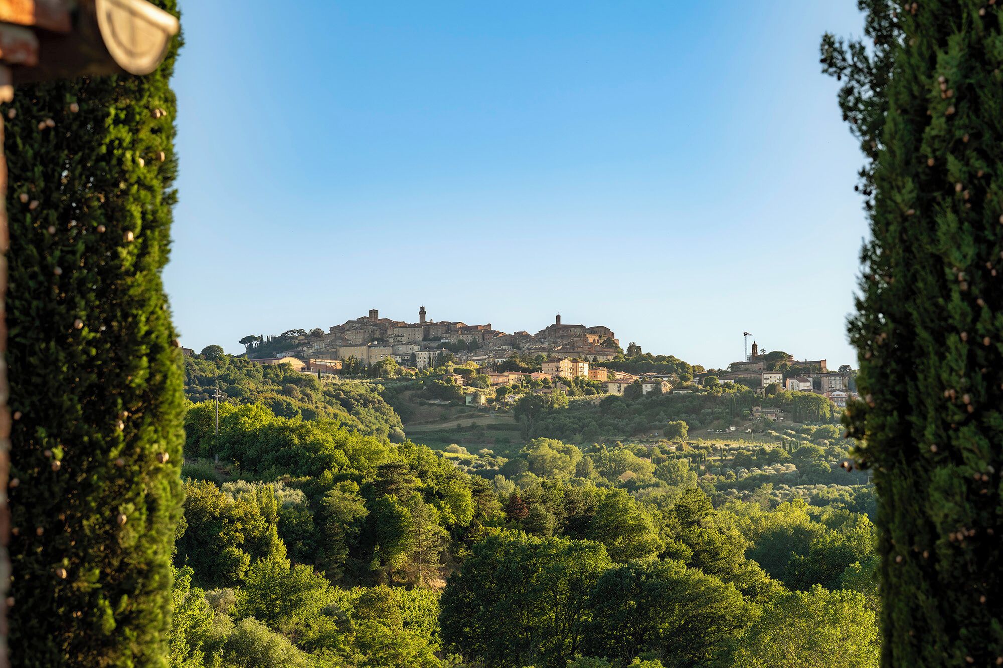 A historic hilltop town with dense greenery and traditional architecture.