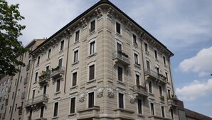 A multi-story building with a classical architectural style, featuring ornate balconies and a symmetrical facade.