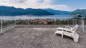 A terrace with a view of a lake and mountains, featuring two white lounge chairs. - Beautiful apartment for 2 people with WIFI, A/C, pool and terrace (Germignaga)