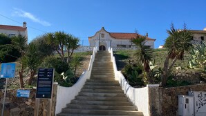 A staircase leading to a building with a tiled roof, surrounded by greenery and a cobblestone path. - Casa rustica, Apartment with balcony (Bordeira)