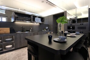 A modern kitchen with a central island, built-in appliances, and a large mirror. - ST Signature Jalan Besar, SHORT OVERNIGHT, 8 hours: 11:59PM-8AM (Singapore)