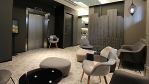 A modern lobby with a reception desk, seating area, and an elevator. - ST Signature Jalan Besar, SHORT OVERNIGHT, 8 hours: 11:59PM-8AM (Singapore)