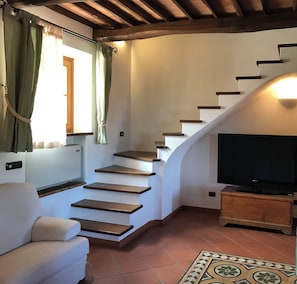 A staircase with wooden steps and a TV on a wooden stand.